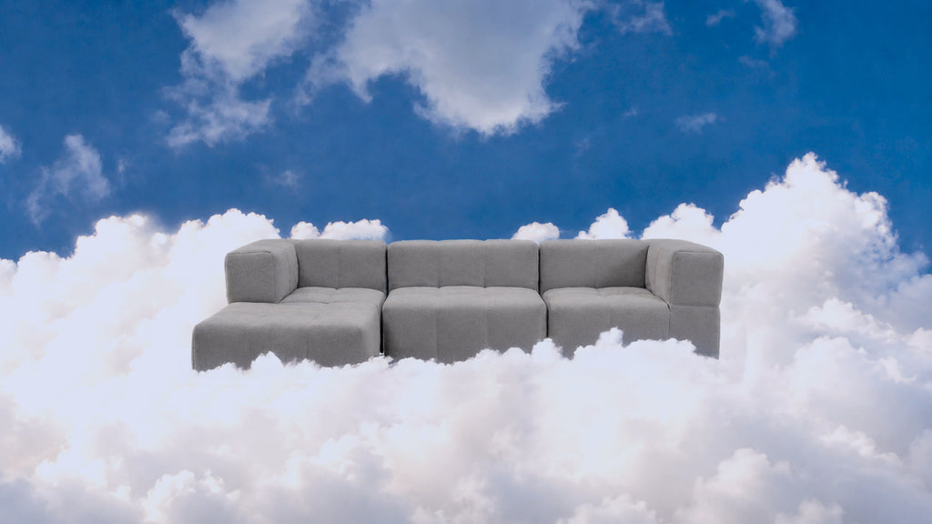 Modulares Sofa Stone Grey im 4er-Set vor Wolkenhintergrund